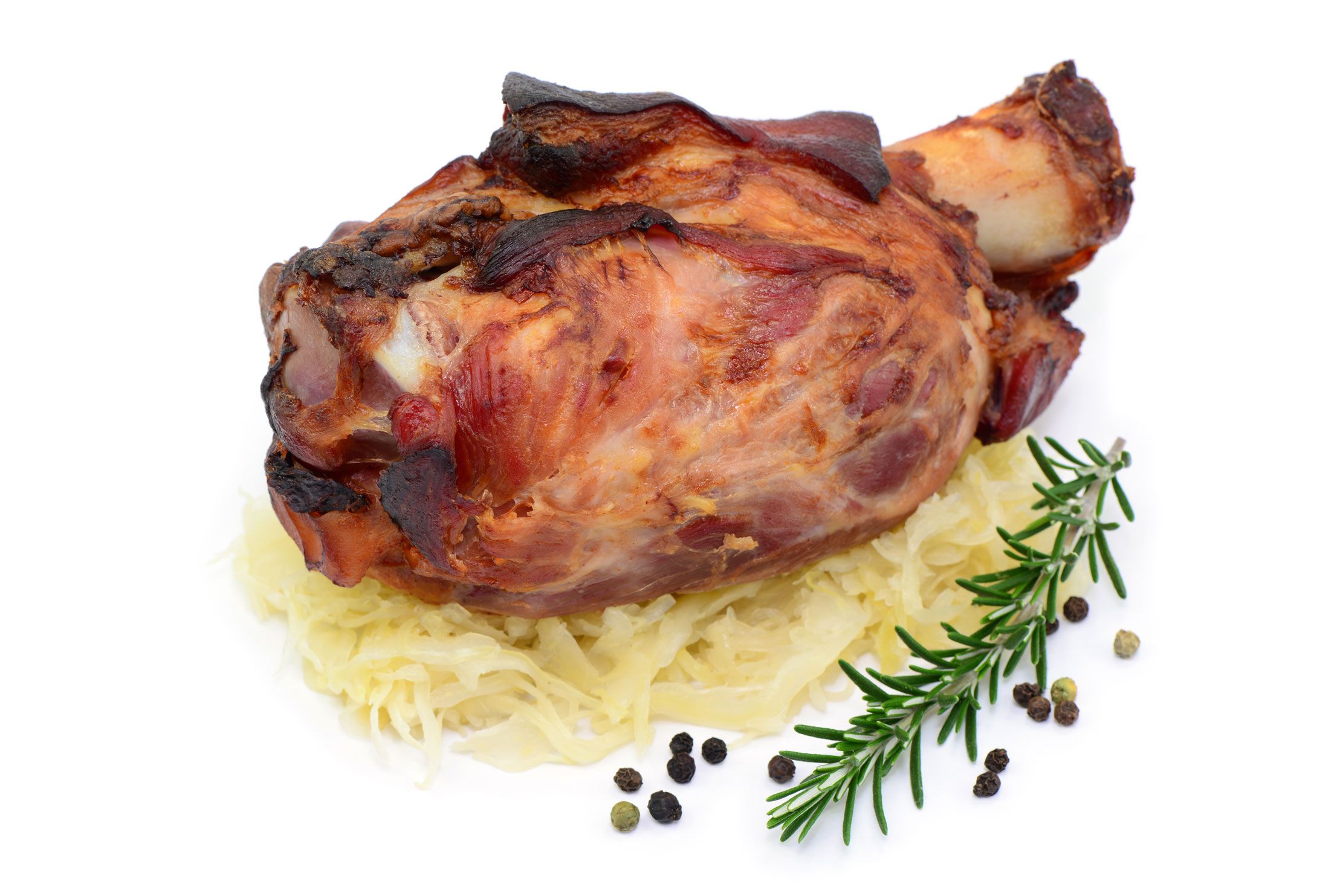 knusprige schweinshaxe auf sauerkraut und rosmarien garnierung