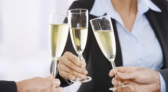 Drei Sektgläser zum Anstoß hochgehalten, Prost auf einer Geschäftsfeier im Restaurant nahe Berlin.